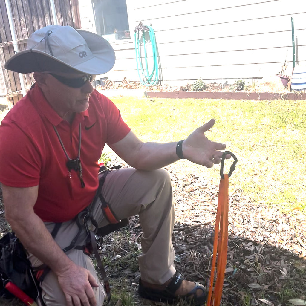 Man demonstrating anchor basics for use with rope and harness preparing to scope a roof.