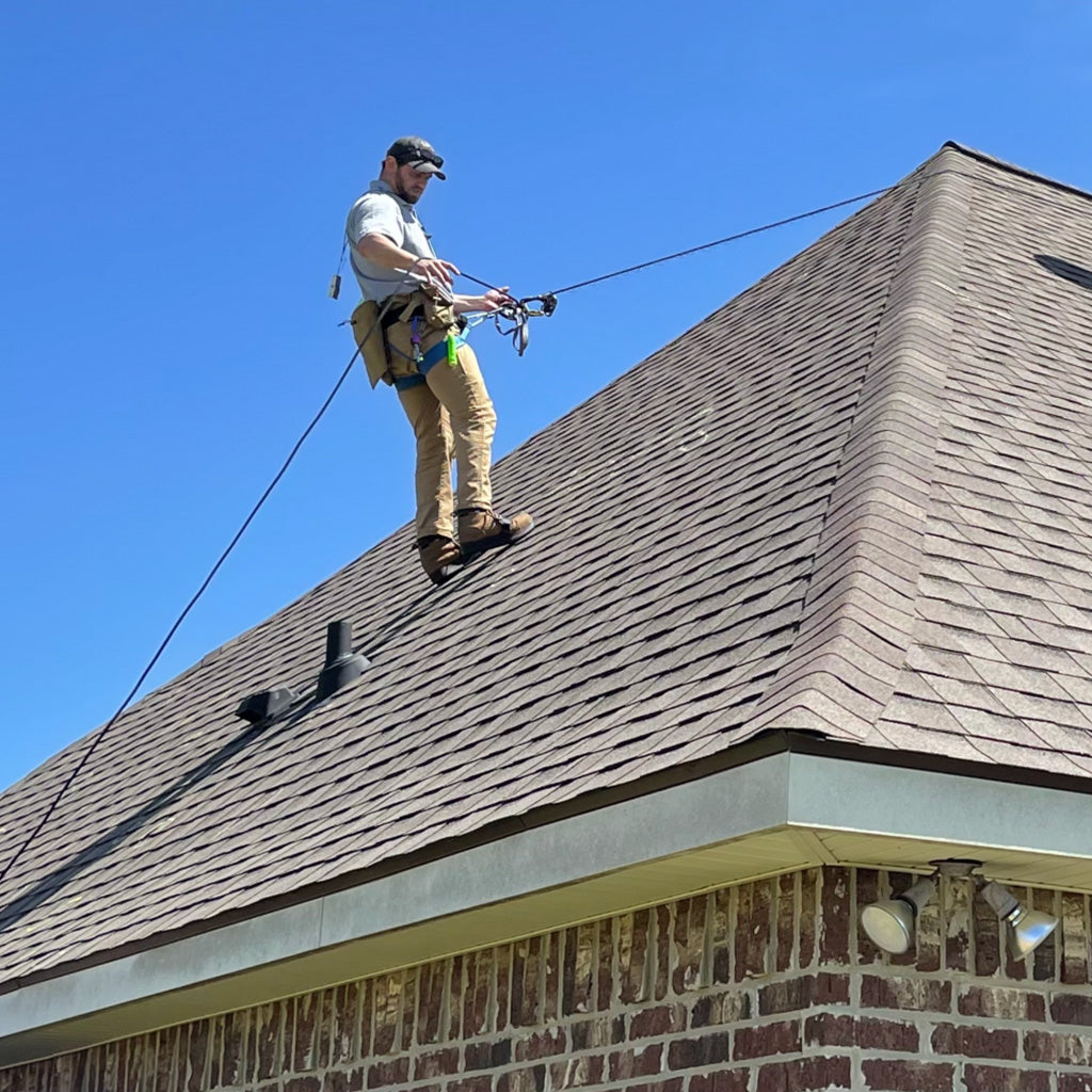 Image showing a man using a prusik loop to inspect a hip roof