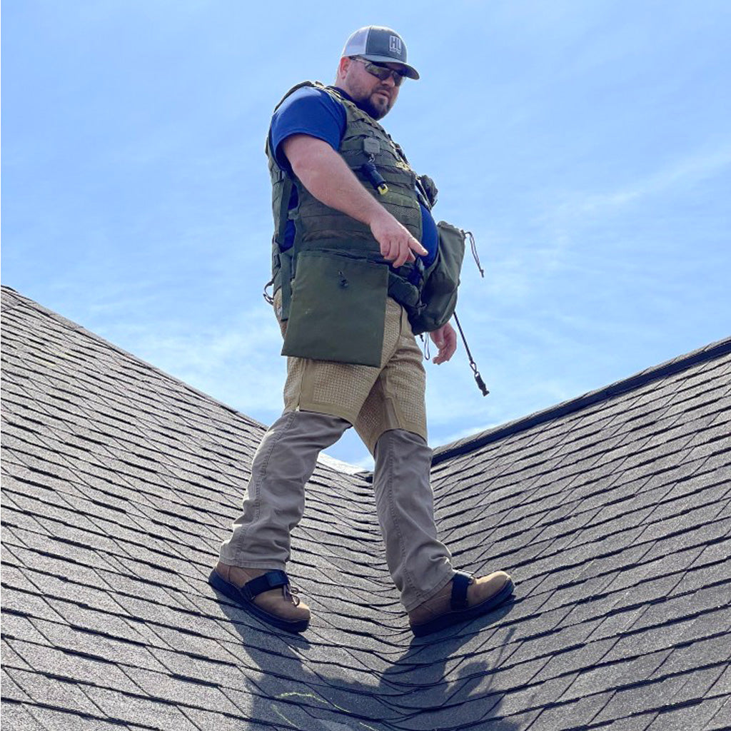 Man on roof with a pair of SteepGear shorts worn over pants as additional fall protection.